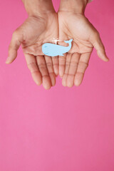Fish-shaped paper, empty on hand, isolated from pink background.