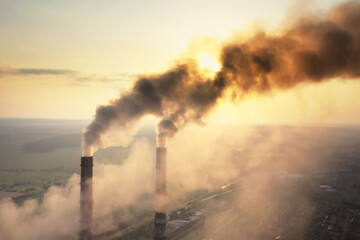 Aerial view of coal power plant high pipes with black smoke moving up polluting atmosphere at...