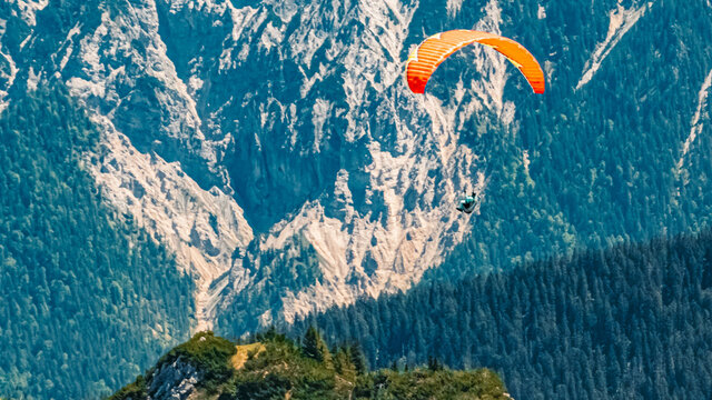 Beautiful alpine summer view with a paraglider at the famous Alpspitze summit near Garmisch Partenkirchen, Bavaria, Germany