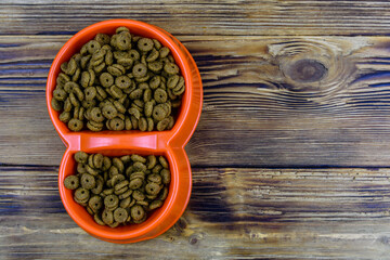 Bowl with pet food on a wooden background. Top view