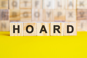 word hoard is written on wooden cubes on a bright yellow surface, concept
