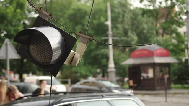 Traffic light hangs from a power cable, it was broken due to hurricane winds.