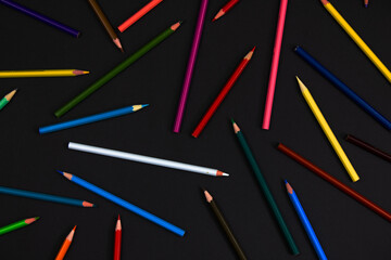 Multicolored pencils on a black background. Back to school concept.