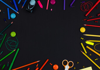 Multicolored stationery on a black background. Copy space. Back to school concept