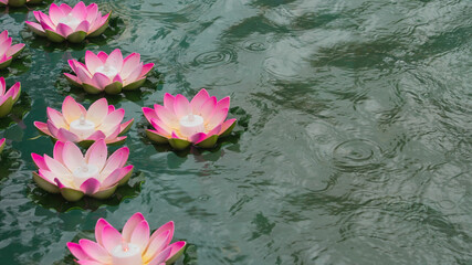 Buddhist decorative lotus flower candles floating in a pond