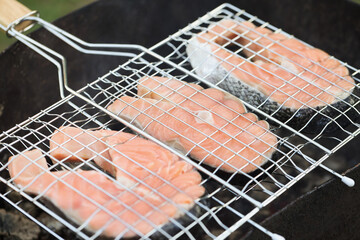 Grilled fish salmon pieces on hot grill closeup