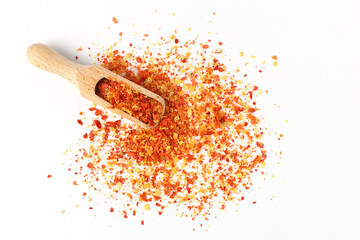 Dried red chili flakes in wooden spoon, isolated on white background. Chopped chilli cayenne pepper. and herbs. - Powered by Adobe