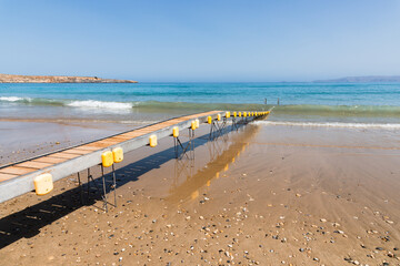 Safe motorized wheelchair ramp, used to transport disabled people into the sea water for swimming. Heraklion, Crete, Greece
