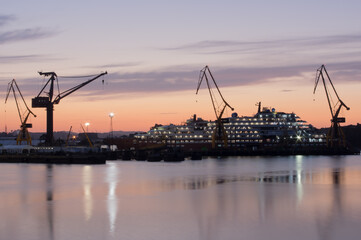 Night photo of a ship in a shipyard.