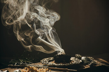 Charcoal burning with incense, incense resin, rosemary, laurel, lavender on a rustic wooden table, 
smudge stick, smudging, energetic cleansing and smoking.Sahumar
 - Powered by Adobe