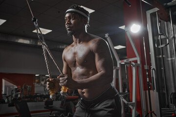 Fototapeta na wymiar Workout in gym, sport and healthy lifestyle concept. African american athletic man with naked torso making exercises
