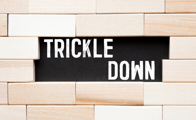 text Trickle down on wooden block, business concept