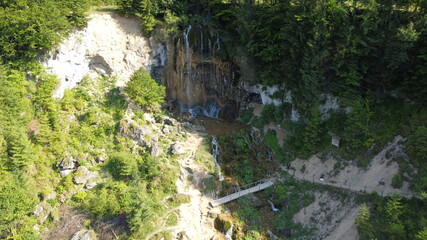 Fototapeta na wymiar Waterfall in the national park. Waterfall full of mosses. Waterfall Pisoaia