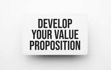 Develop your value proposition sign on notepad on the white backgound