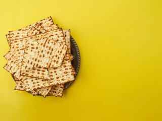 Matzakh - traditional Jewish bread on a yellow background. Jewish Passover. Spring holiday. Religion, traditions, rituals, prayer, Torah. There are no people in the photo. Color image.