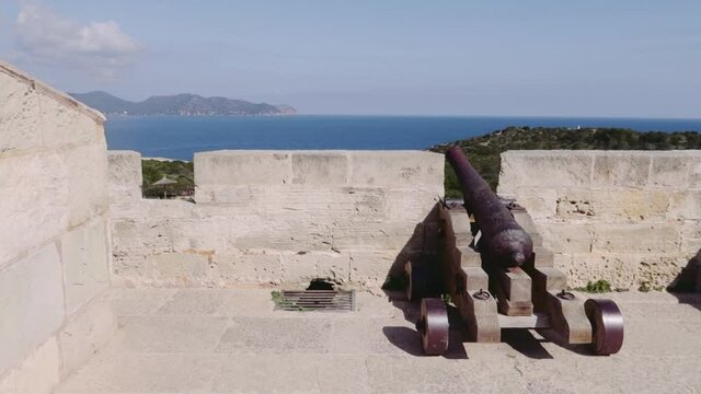 A closeup of a canon in the stone Castell near Cala Millor in Mallorca, Spain near the ocean
