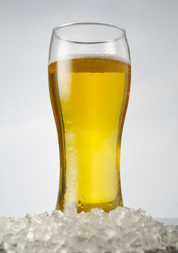 A glass of light beer on a plain white background. Macro photography. Minimalism. Restaurant, pub, cafe. Advertising and hotel business. Banner, poster.