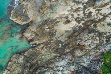 Aerial view top down of seashore waves and fantastic Rocky coast view Stones texture natural background.