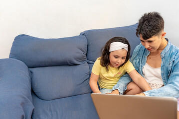 Mother and daughter in the sofa using the computer.