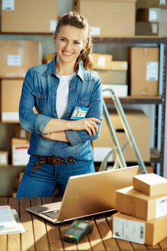 smiling modern female in jeans with laptop in office