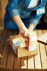 Closeup on female in jeans with parcels in warehouse