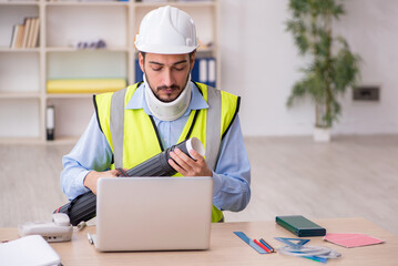 Young neck injured male architect in safety concept