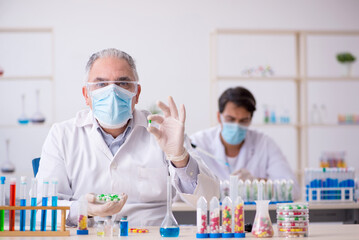 Fototapeta premium Two male chemists in drugs synthesis concept at the lab