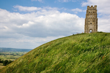 St Michael's Tower on the Glastonbury Tor under a blue cloudy sky in the UK © Steve Taylor1/Wirestock