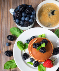 Pancakes for breakfast with blackberries and strawberries. Fluffy and delicious buttermilk pancakes.