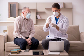Young male doctor visiting old patient in vaccination concept
