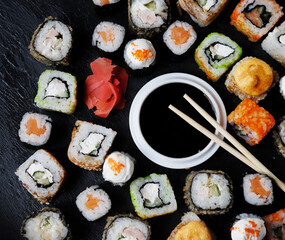 Set of sushi and maki with soy sauce on stone table. Flat lay, top view