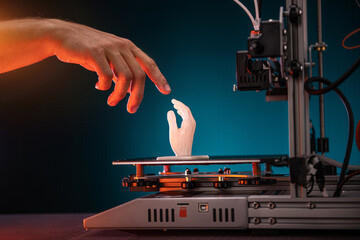 3D printing in progress. 3d printer printed a hand. A man touches the product printed on a 3d...