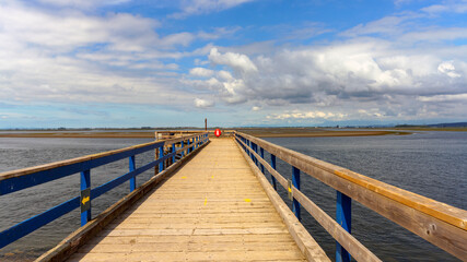 Fototapeta na wymiar Lonely pier at Crescent Beach, BC, overlooking exposed mudflats at low tide