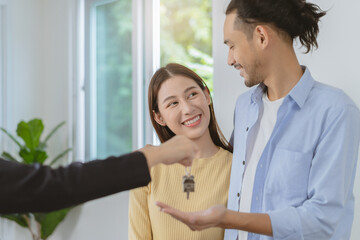 Happy asian couple client, tenant buy home ,apartment. Realtor holding key chain giving new landlord after sign signature contract rental purchase, bank approve mortgage, loan. Property of financial.