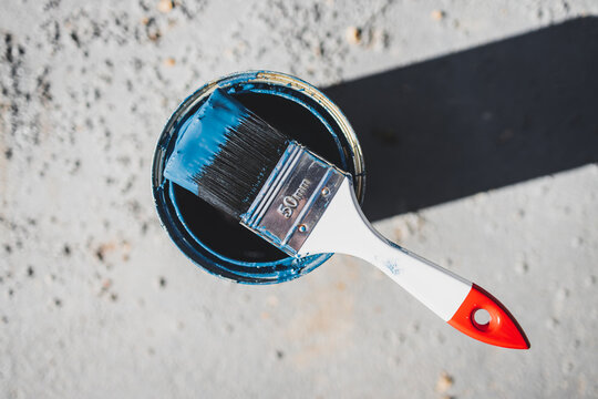 DIY And Home Improvement, Open Pot Of Blue Outdoor Paint With Paint Brush On Top