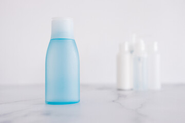 low tox and non-toxic natural beauty products, blue lotion bottle in the foreground standing out from group of other bottles