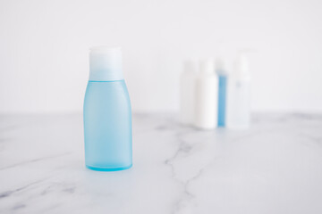 low tox and non-toxic natural beauty products, blue lotion bottle in the foreground standing out from group of other bottles