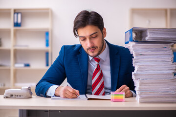 Young businessman employee unhappy with excessive work in the office