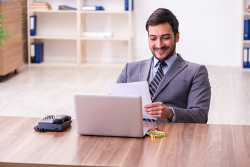 Young handsome businessman employee working in the office