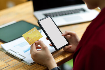 Cropped shot female holding phone and credit card