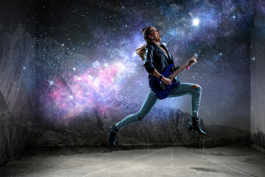 Young and beautiful rock girl playing the electric guitar