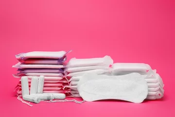 Foto op Canvas Many menstrual pads and tampons on pink background © New Africa