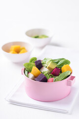 Fresh fruit and vegetable salad with avocado, dragon fruit, pumpkin, radish, lettuce and corn salad. Concepts of healthy food, vegetarian and lifestyle trends.