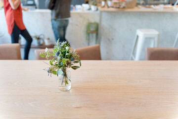 Closeup of nature leaves in vase on wooden table