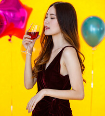 Asian beautiful confident girl in sexy dress standing crossed arm holding cheers toasting red wine...