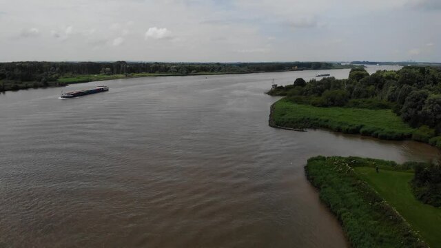 Aerial Flying Over Oude Maas In Barendrecht, With Cargo Ship In Background. Dolly Right