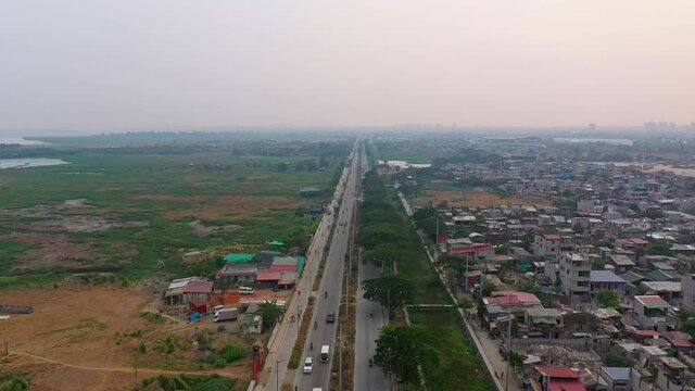 Panorama Of Vehicles Traveling At The City Road Of Taguig Between Residential Area And Vacant Landscape In The Philippines. aerial