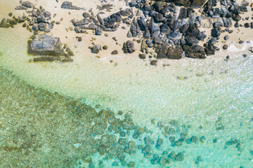 Aerial drone shot of beautiful paradise sand with rock beach with clear turquoise sea. Summer and travel vacation concept