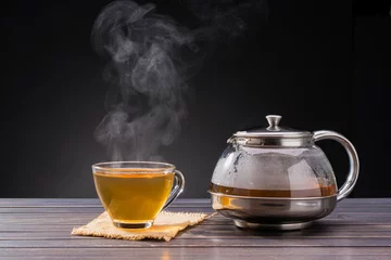  organic hot tea placed on a wooden table on a black background © WIROT