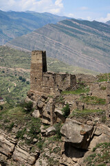 Fototapeta na wymiar ancient stone battle tower in abandoned village old Kahib in Dagestan with scenery mountain valley background